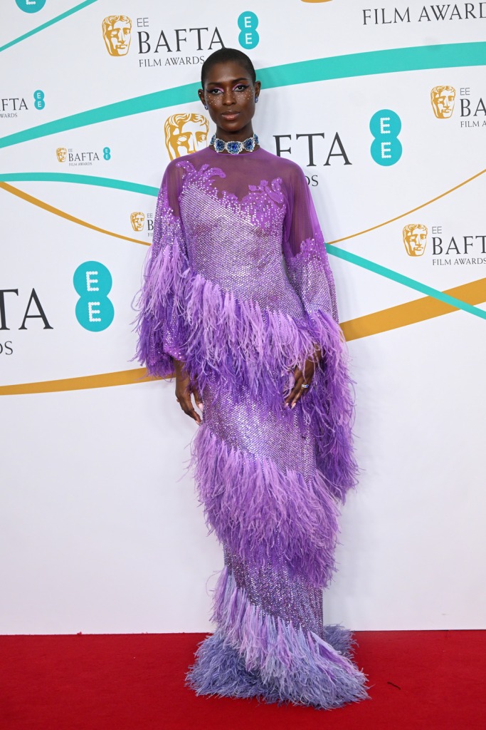 Jodie Turner-Smith porte une robe violette à plumes sur le tapis rouge des BAFTA 2023.
