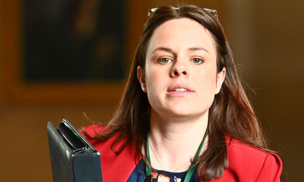 Une image de Kate Forbes dans un blazer rouge.