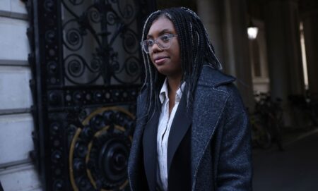 Kemi Badenoch walking through a street in London.