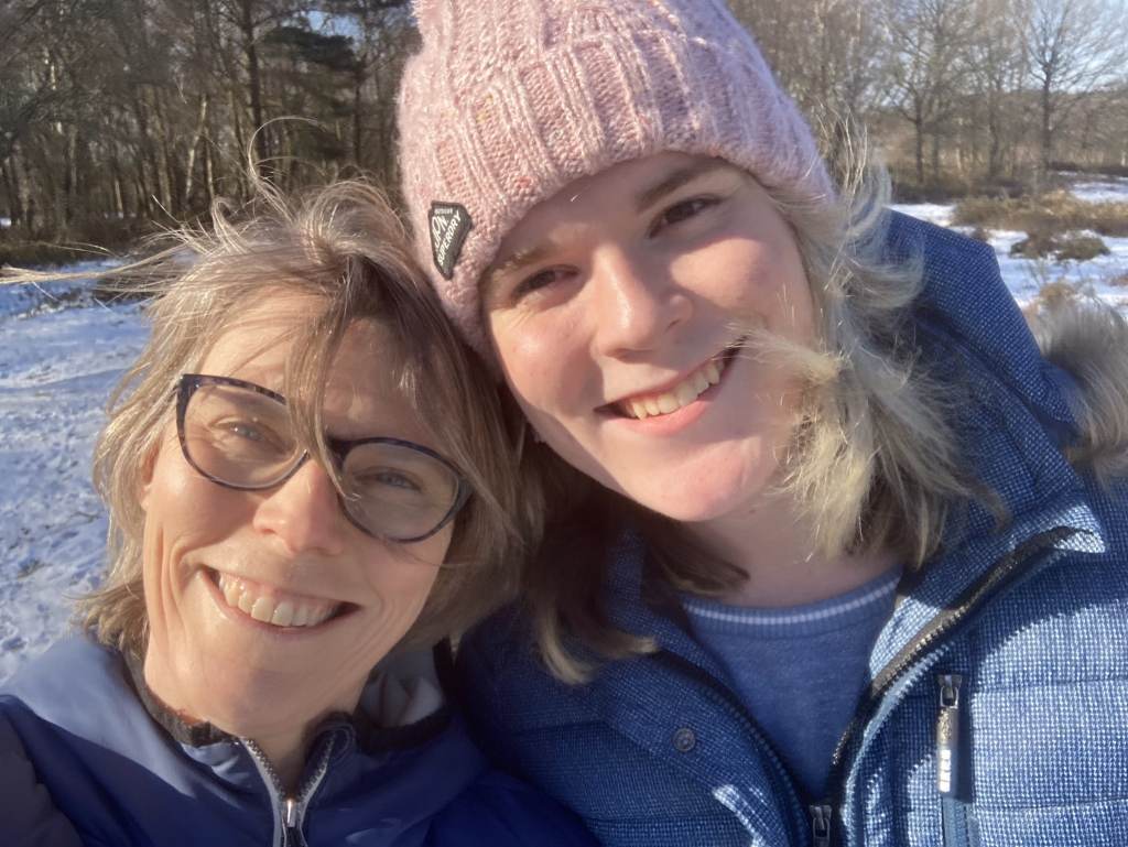 Alice Litman et sa mère souriantes, avec de la neige visible sur le sol derrière elles