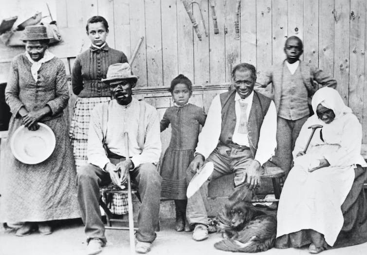 Un groupe d'hommes et de femmes noirs pose pour un portrait.