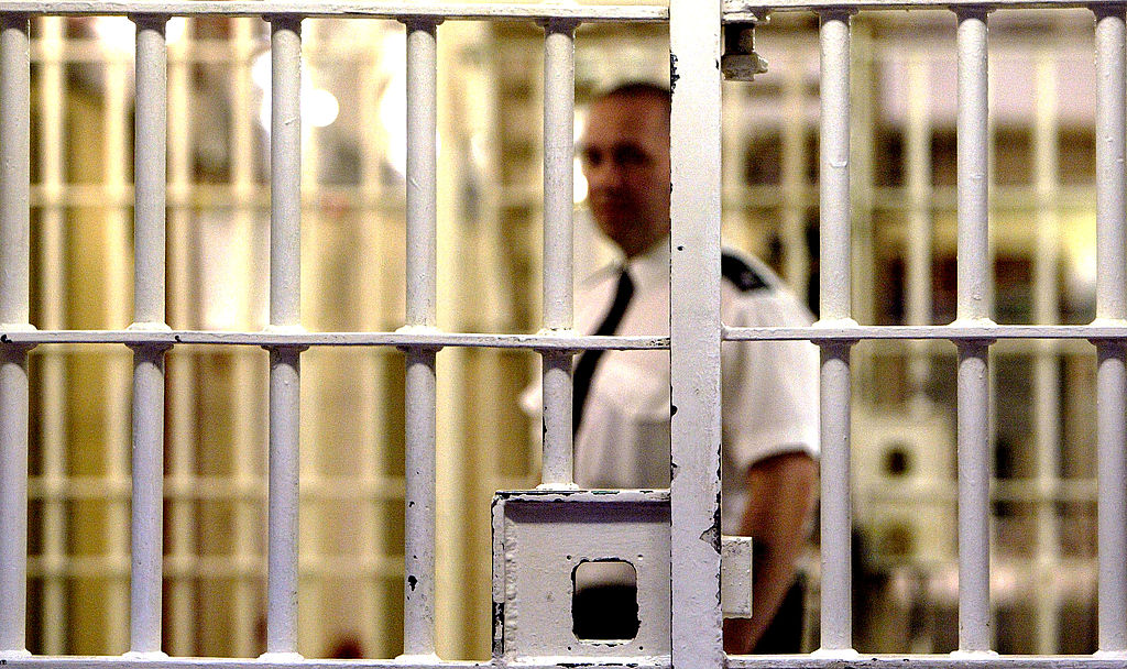 Un gardien de la prison de Pentonville se tient derrière une porte verrouillée.