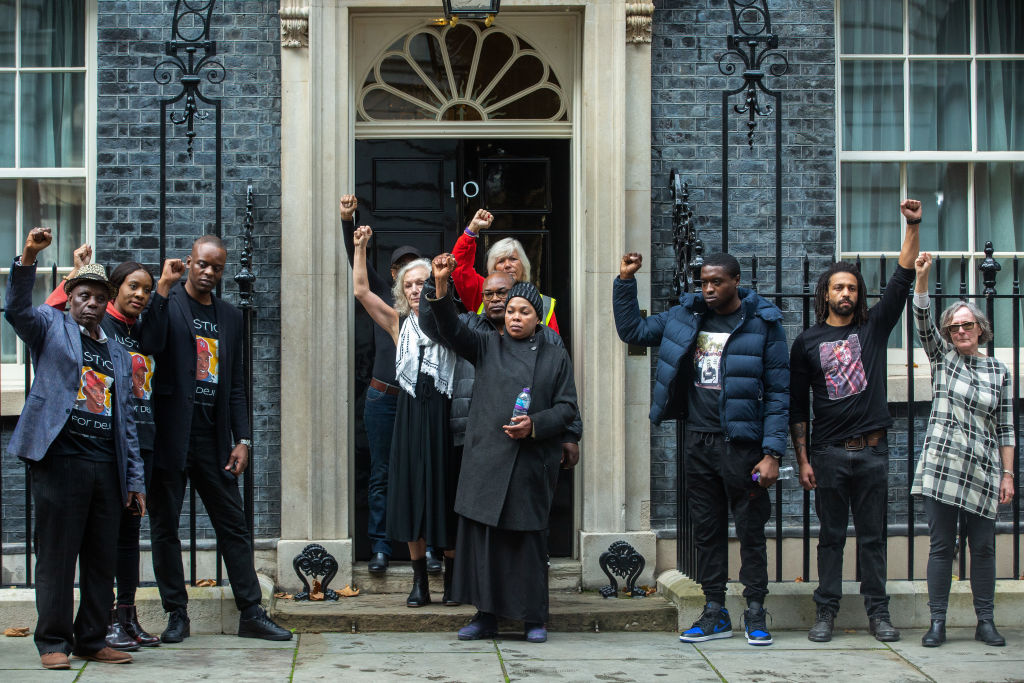 Les proches d'Oladeji Omishore, Mark Duggan, Leon Patterson, Matthew Leahy, Chris Kaba, Mouayed Bashir et Jack Susianta lèvent les poings fermés devant le 10 Downing Street après avoir présenté des lettres au Premier ministre au nom de la United Families and Friends Campaign (UFFC). 
