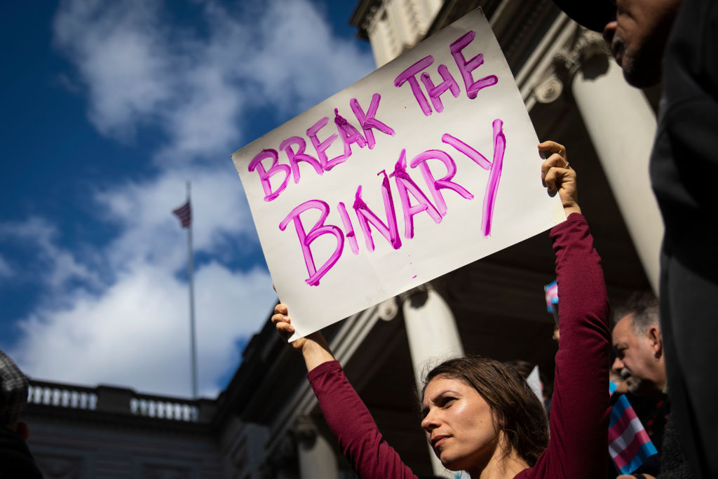 Des militants LGBTQ+ et leurs partisans se rassemblent pour soutenir les personnes transgenres sur les marches de l'hôtel de ville de New York en 2018.