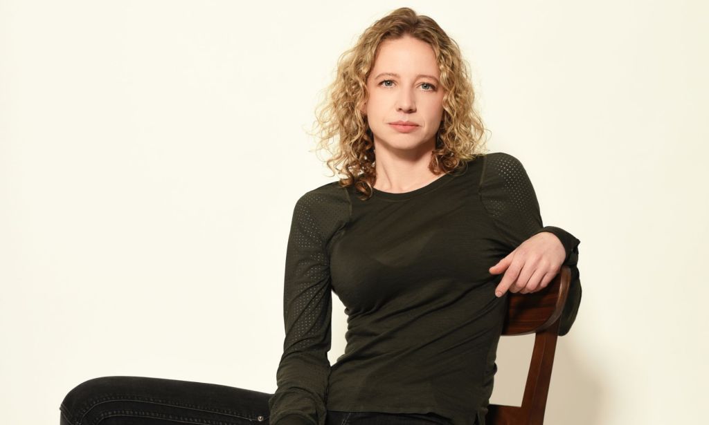 Zandara Kennedy, cascadeuse et conductrice de drift professionnelle, porte une tenue noire alors qu'elle est assise sur une chaise et pose pour la caméra