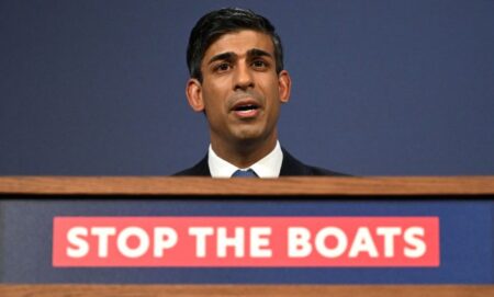 Rishi Sunak announcing the Illegal Migration Bill at a podium with the message "stop the boats".