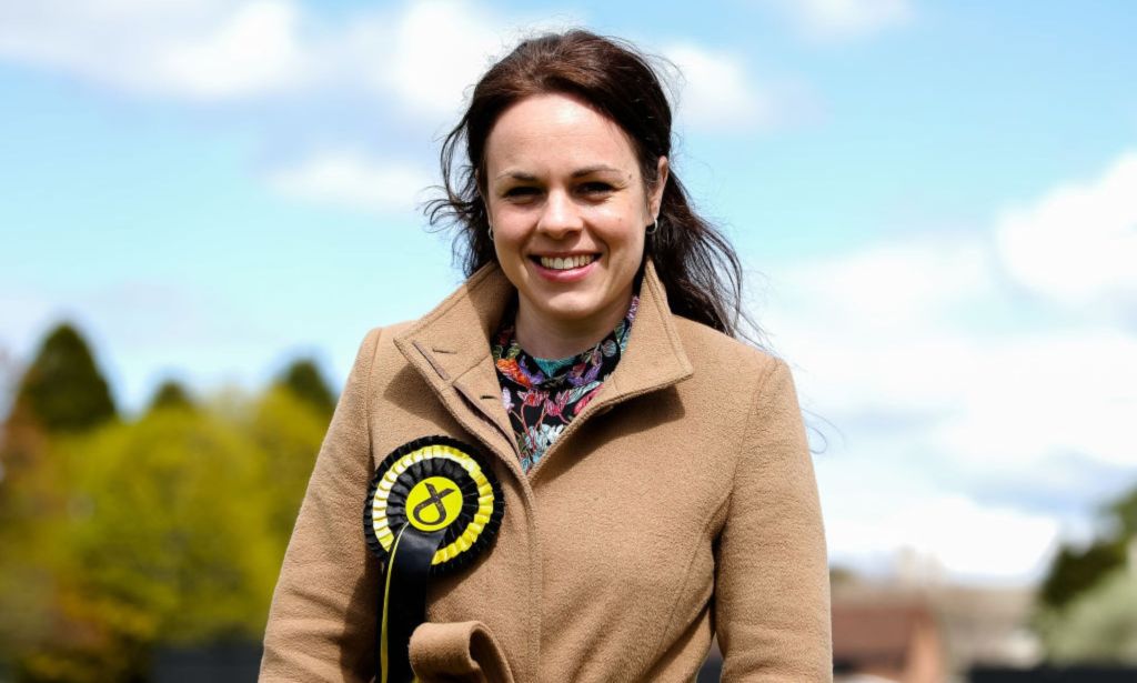 Kate Forbes, l'une des candidates à la direction du SNP, photographiée sur la campagne électorale portant un badge SNP à l'extérieur.  Les arbres peuvent être vus en arrière-plan.