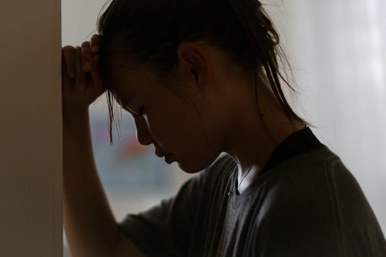 Une jeune femme inquiète de profil stressée et malheureuse.