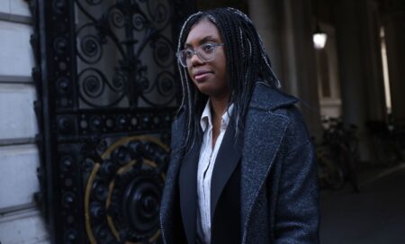 Kemi Badenoch walking down a London street.