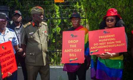 Uganda protestors hold signs urging the president to drop the anti-gay bill.