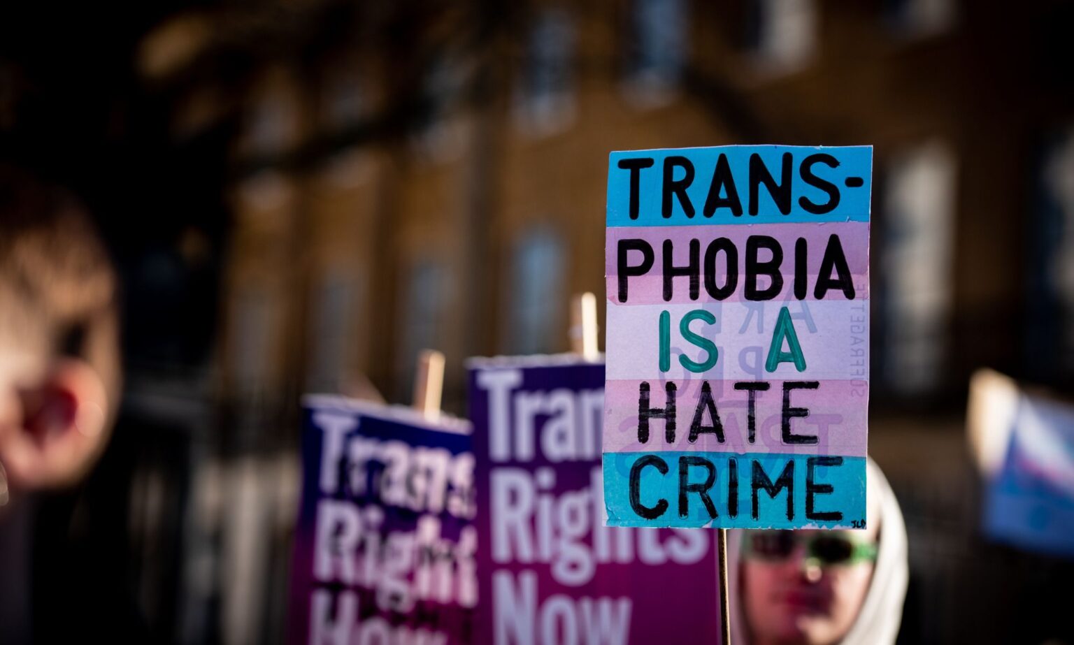 EHRC « nuit » à la communauté trans et est une « institution défaillante », préviennent les groupes LGBTQ+ A person holds up a sign in the colours of the trans pride flag (blue, pink and white) reading 'Transphobia is a hate crime' during a protest
