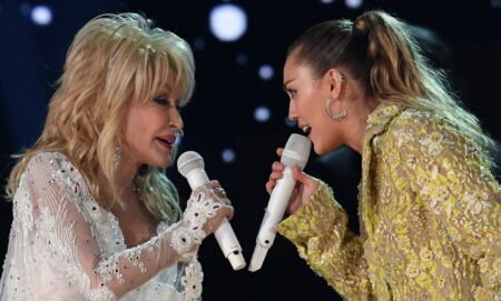 Miley Cyrus and Dolly Parton on stage, singing Rainbowland together.