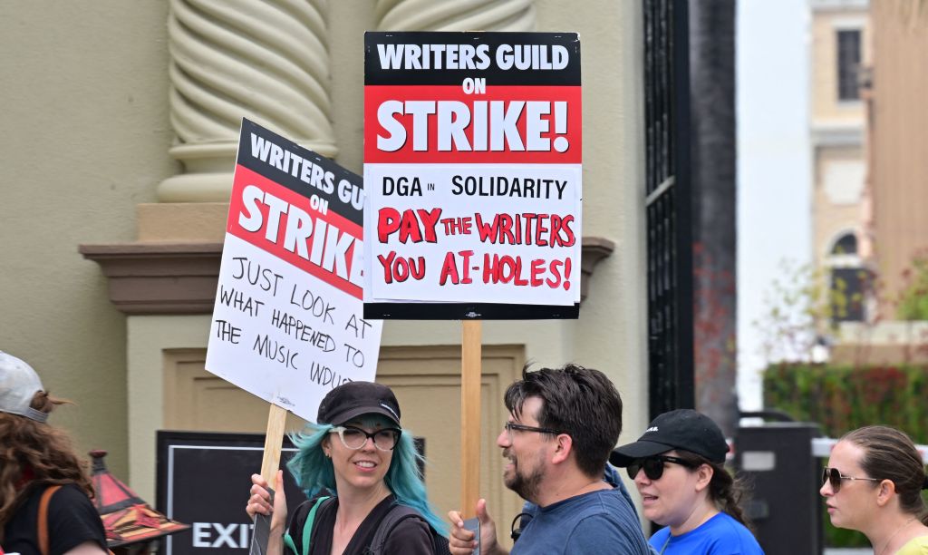 Des écrivains tiennent des pancartes lors d'un piquetage devant les studios Paramount à Los Angeles, en Californie, le 15 mai 2023. 