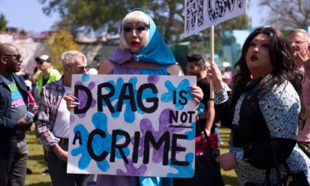 A person holds up a sign reading 'drag is not a crime' amid a protest against surging anti-LGBTQ+ bills in the US like Tennessee's drag ban