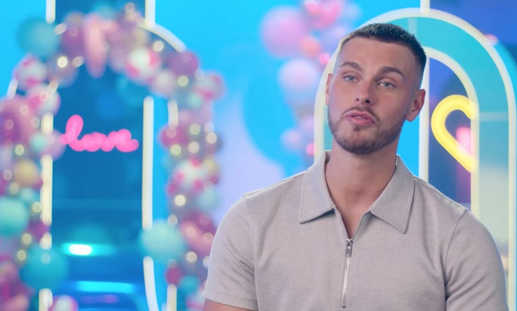 Le candidat de Love Island 2023, George Fensom, porte une chemise grise alors qu'il s'assoit pour une interview