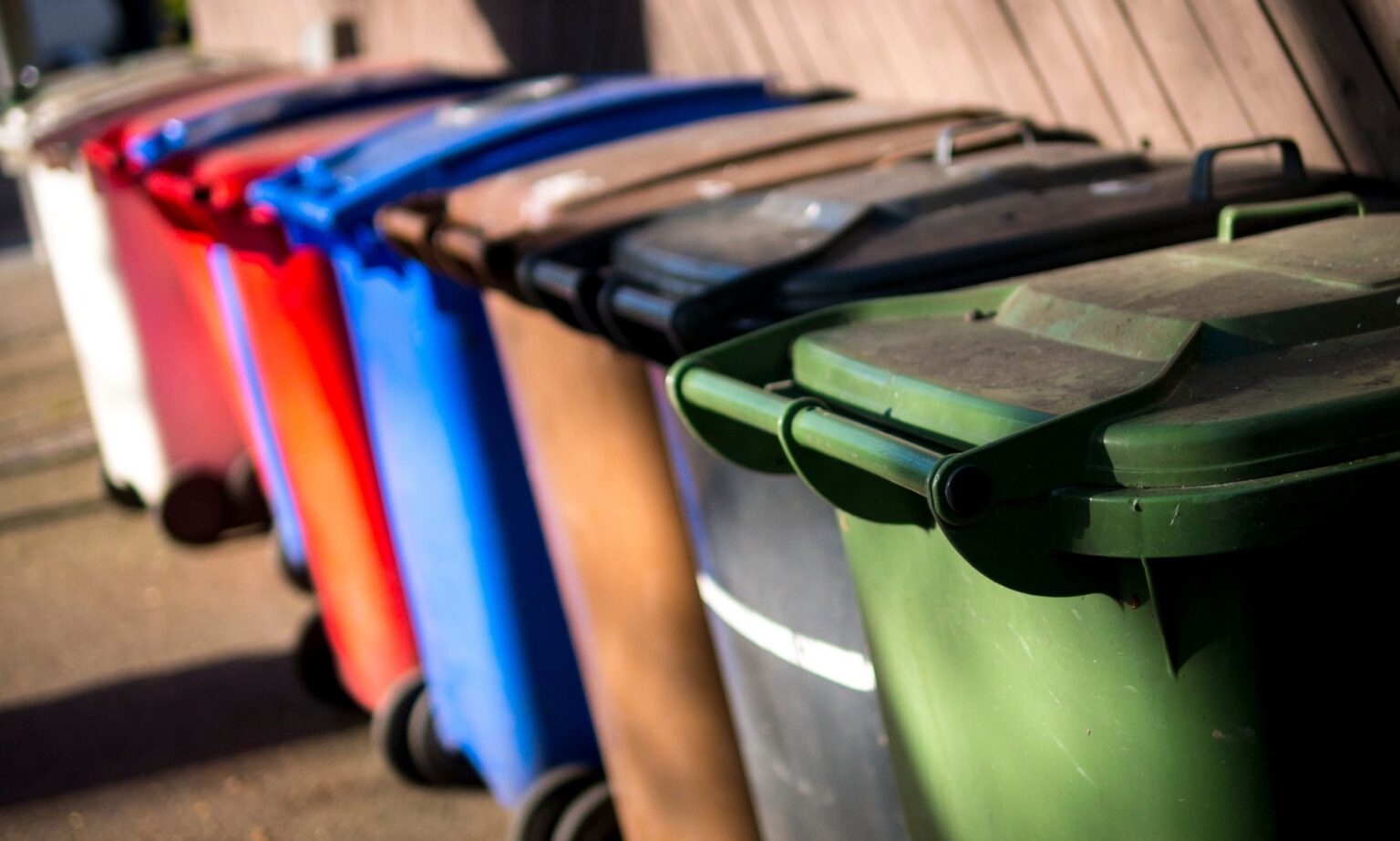 Un homme gay reçoit des menaces de mort homophobes pour avoir déplacé la poubelle à roulettes d’un voisin A set of UK wheelie bins, each a different colour, lined up against one another.