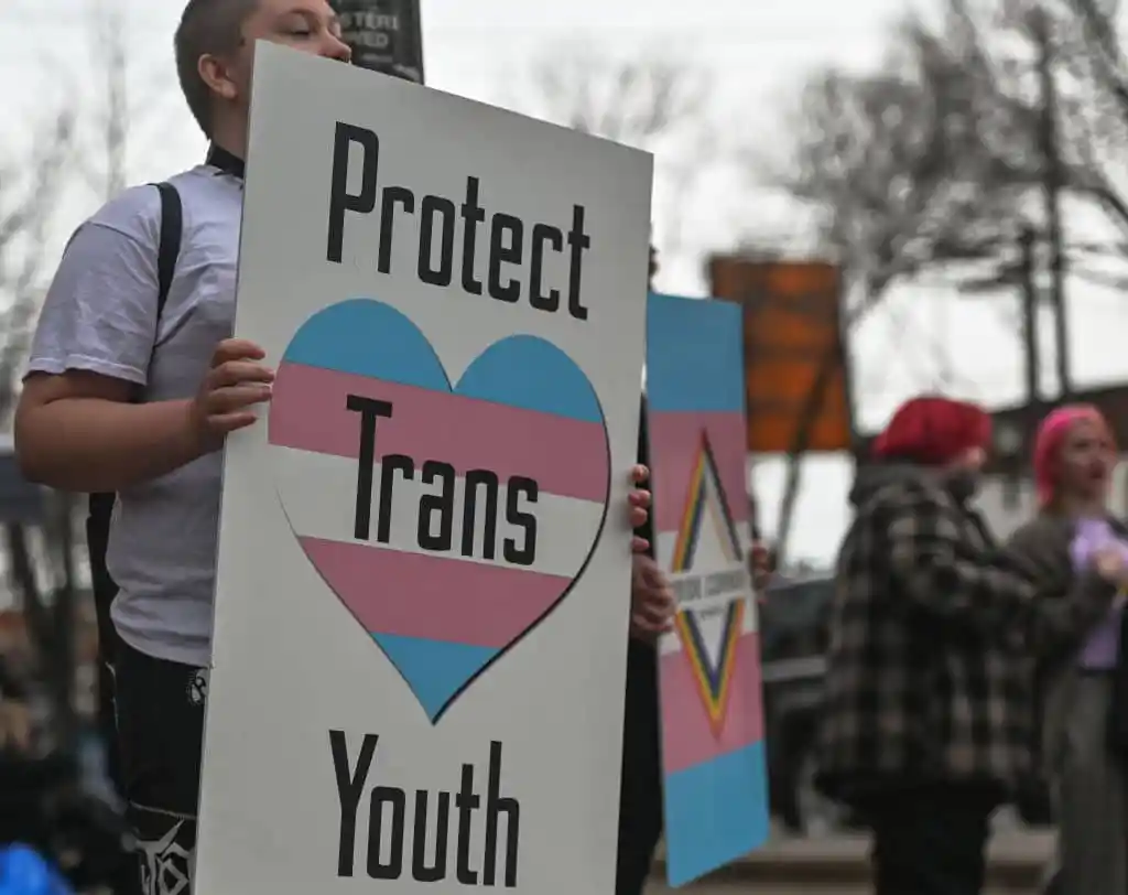L’interdiction du Tennessee sur les soins affirmant le genre pour les jeunes trans est rétablie An activist holds a placard with words