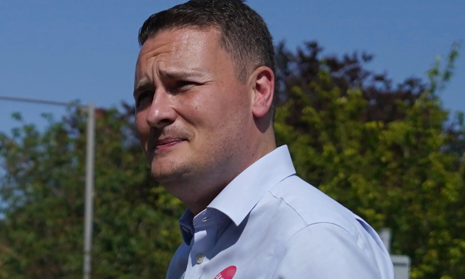 Le député gay Wes Streeting fait face à des réactions négatives suite aux excuses de Rosie Duffield pour ses opinions critiques sur le genre Wes Streeting wears a blue button shirt while walking around outside.