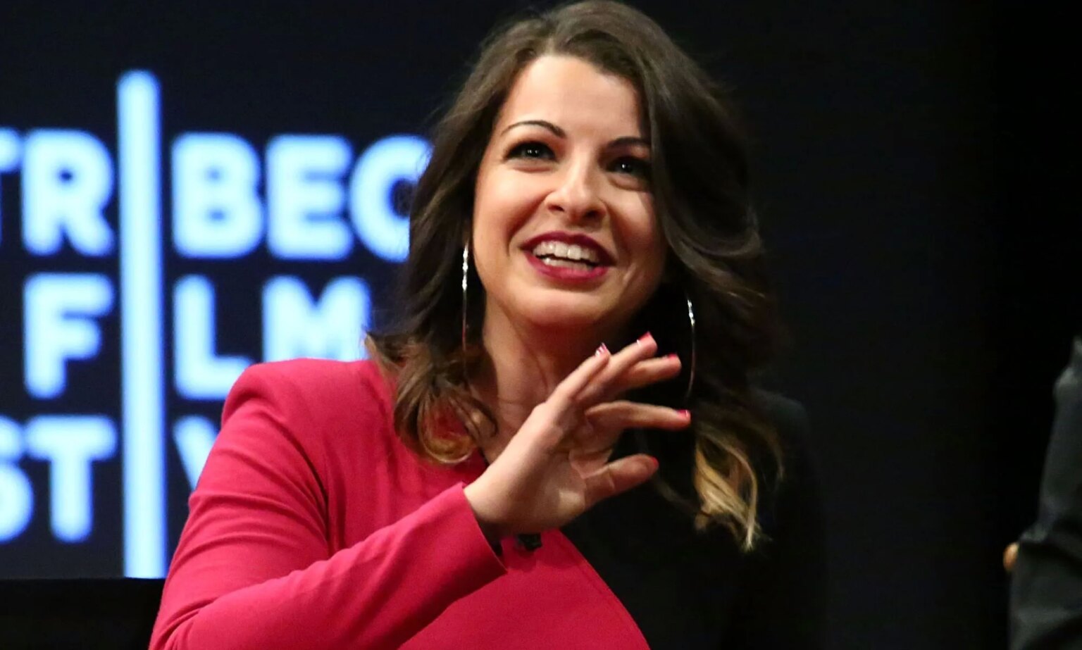 Feminist Frequency ferme ses portes après plus d’une décennie de trolling et d’abus misogynes Anita Sarkeesian, in a black and pink dress, speaks at an event.