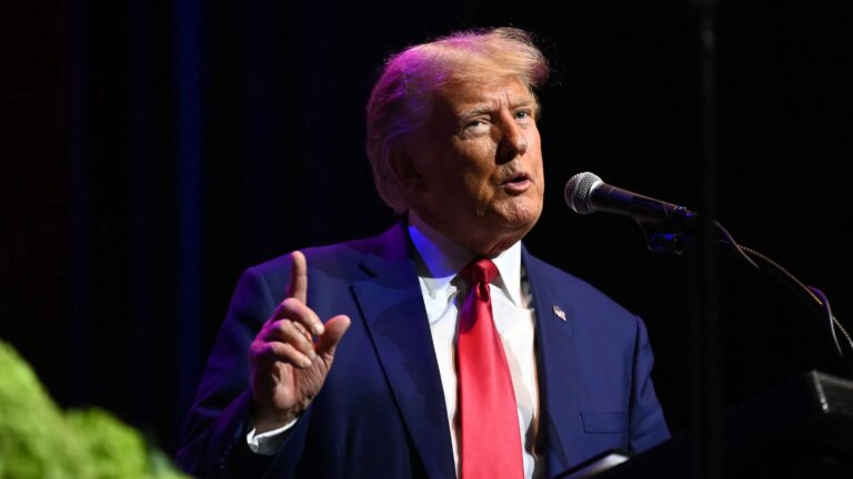 Former US president Donald Trump wears a blue jacket with a red tie