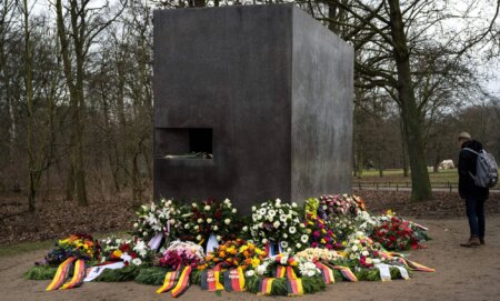 The Tiergarten Holocaust memorial in Berlin, Germany surrounded by flowers.