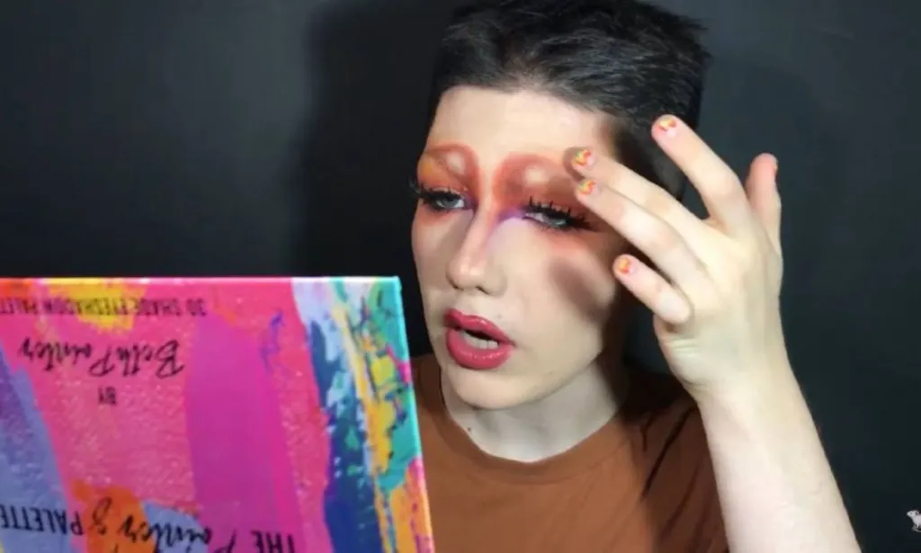 Max, étudiant gay russe, tient une palette de maquillage pendant qu'elle réalise un tutoriel de beauté