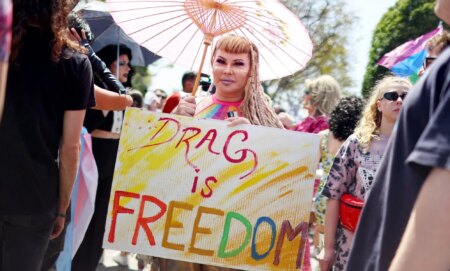 A person holds up a sign reading