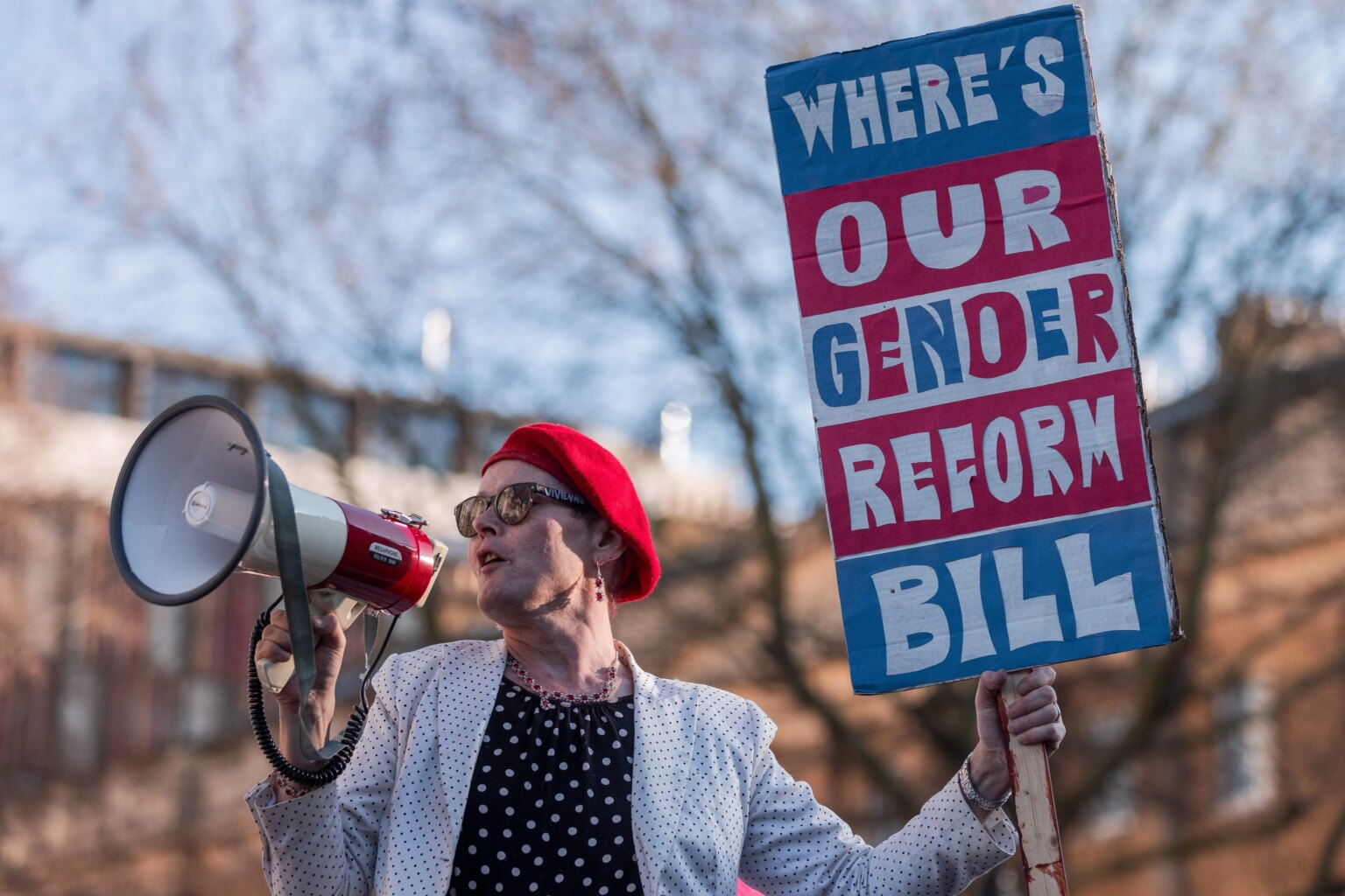 Sarah Jane Baker reconnue non coupable d’incitation à la violence suite au discours de la Trans+ Pride « punch TERF » Activist Sarah Jane Baker holds a sign reading "where