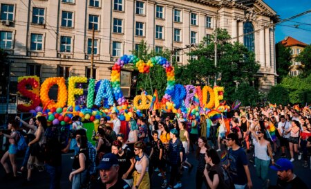 Revellers take part in a Pride parade in Sofia, Bulgaria in 2019 - a large sign written in balloons reads