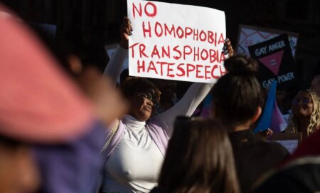 A person holds up a sign reading