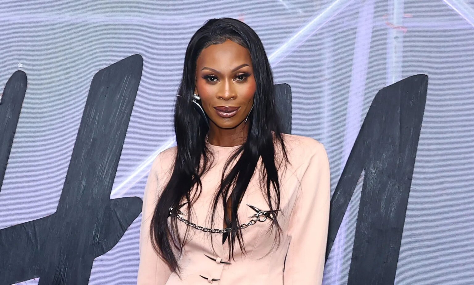 La star de Pose Dominique Jackson « porte toujours beaucoup de peur » après une violente agression Dominique Jackson wears a pink jacket and stands in front of an H&M logo.