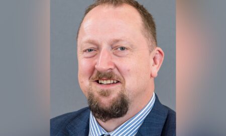 A picture of DUP councillor Colin Kennedy wearing a white and blue striped shirt, blue suit jacket and tie