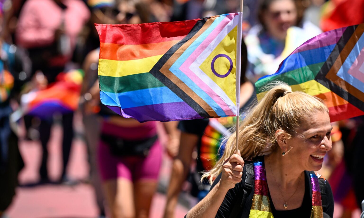 Les 10 villes américaines les plus et les moins favorables aux LGBTQ, selon une nouvelle étude Woman carries an inclusive Pride flag during San Francisco Pride march in June 2022