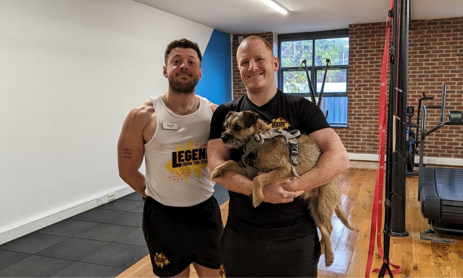 Marre d’être victimes d’intimidation et d’exclusion dans les gymnases traditionnels, deux homosexuels ont décidé d’ouvrir le leur Daniel Browne and Chris Woods of the Leeds People's Gym pictured in their gym posing with a dog.
