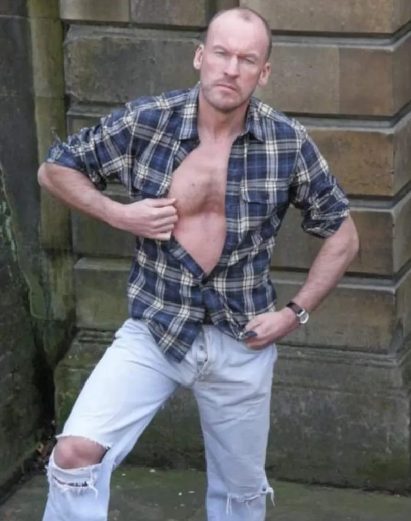 Paul Stag photographié tenant sa chemise ouverte à l'extérieur.