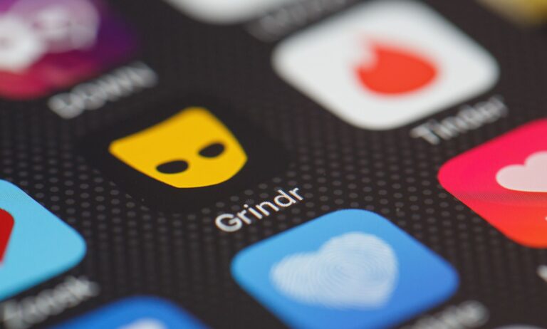 Stock image of the Grindr app logo on a phone