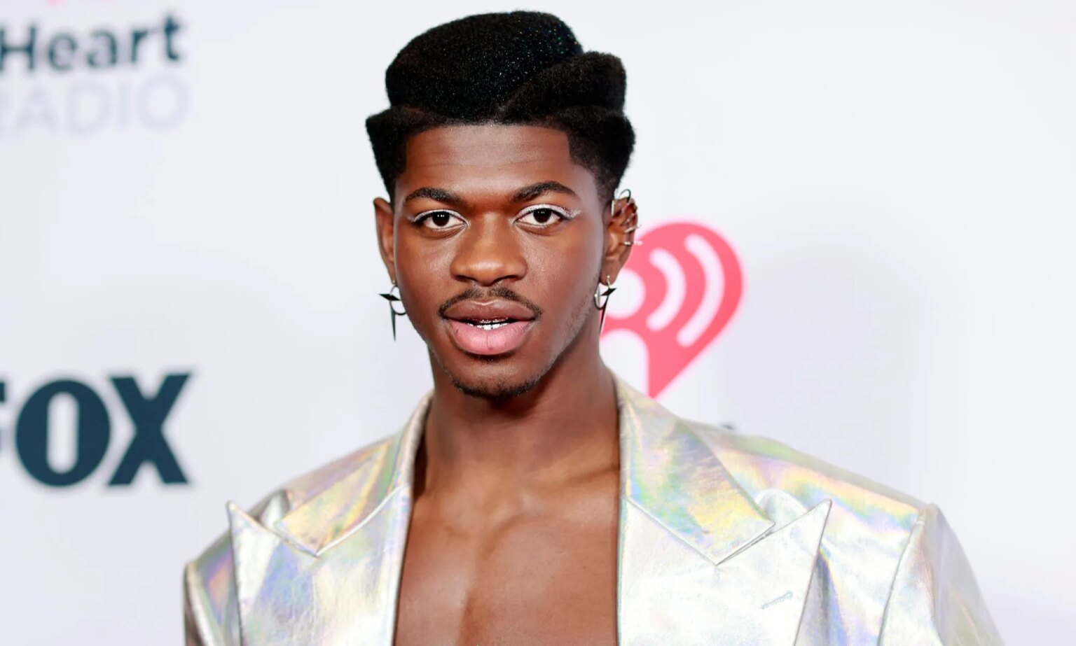 Lil Nas X se moque de la chanson dissidente du rappeur chrétien Lil Nas X topless and in a silver jacket.