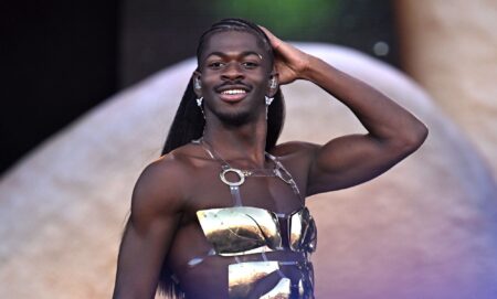 Lil Nas X performs at Glastonbury in a gold-pleated chest piece.