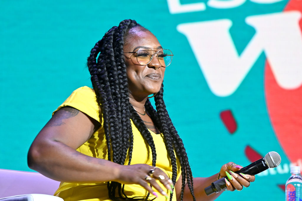 Vêtue de jaune vif, Alicia Garza s'exprime lors d'un panel.