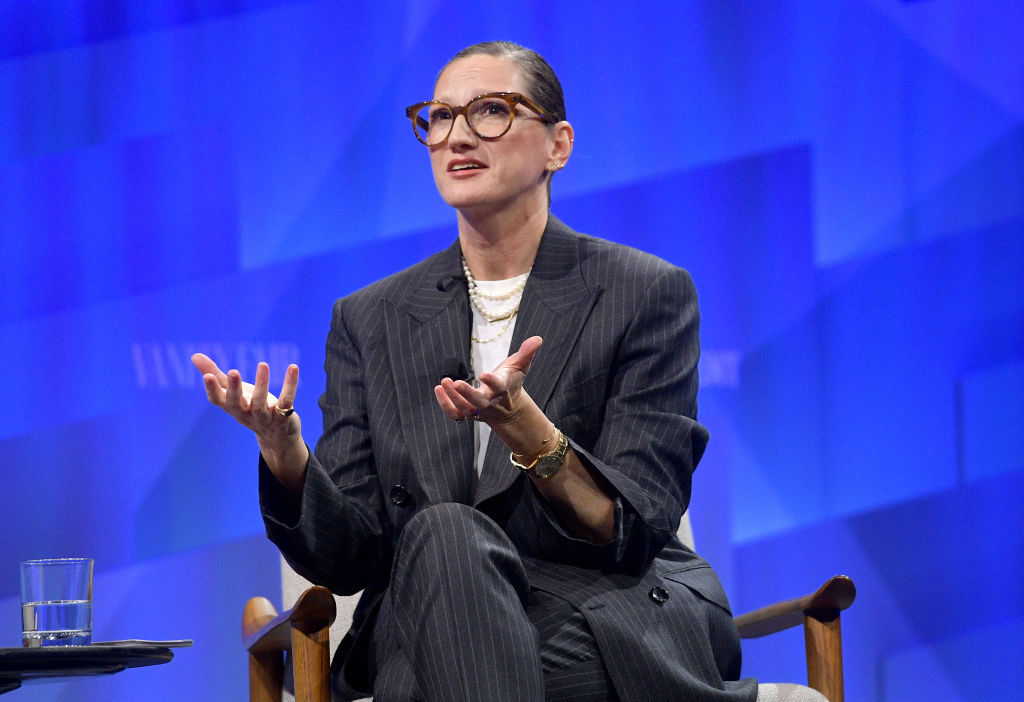 Jenna Lyons est assise en costume au milieu d'une phrase et s'exprime lors d'un panel.