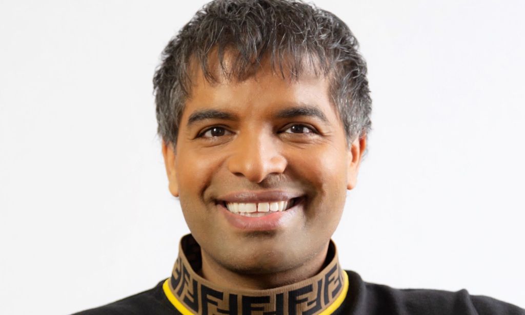 Suki Sandhu sourit et regarde droit dans la caméra. 