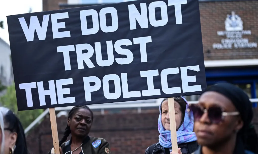 Les manifestants brandissent une pancarte indiquant « nous ne faisons pas confiance à la police »