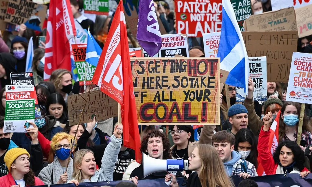Des manifestants pour le climat brandissent des pancartes et des drapeaux