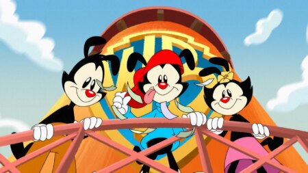 Cartoon image shows three animated characters called Yakko, Wakko and Dot, who are hanging over the balcony of a water tower emblazoned with the Warner Brothers logo.