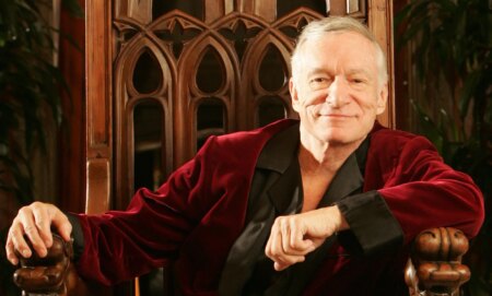 Hugh Hefner in a red and black robe.