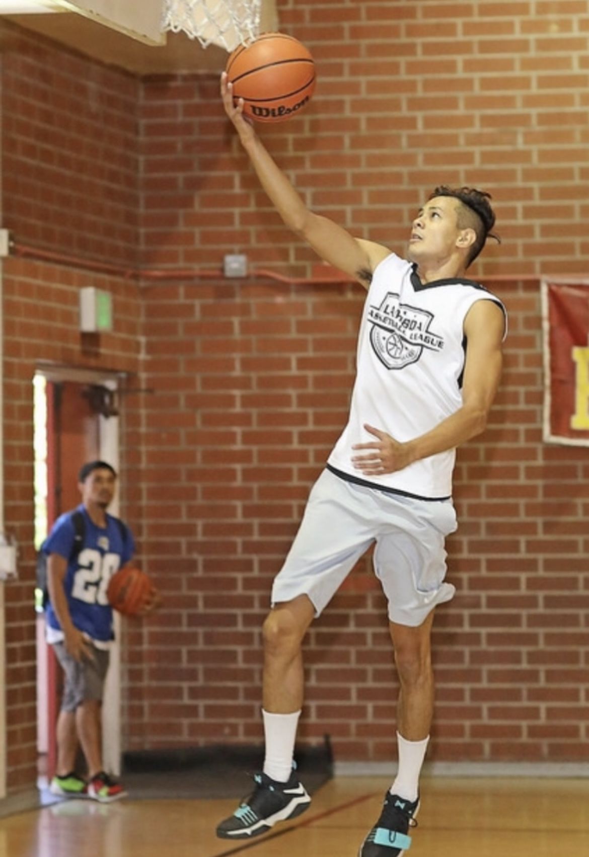 Un podcasteur sportif tente de jouer au basket-ball.