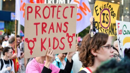 Protester holds a sign reading