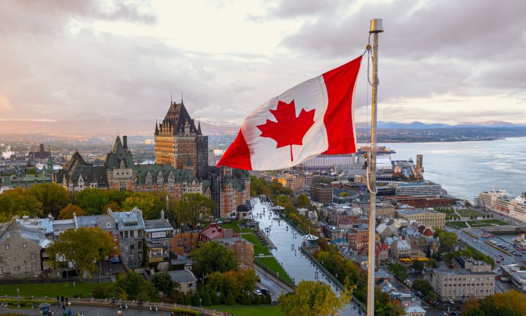 Il s'agit d'une image du drapeau canadien surplombant une petite ville.