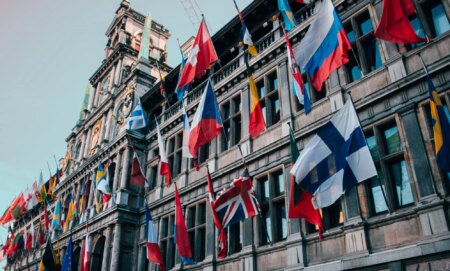 This is an image of a European building adorned with many flags of the world.