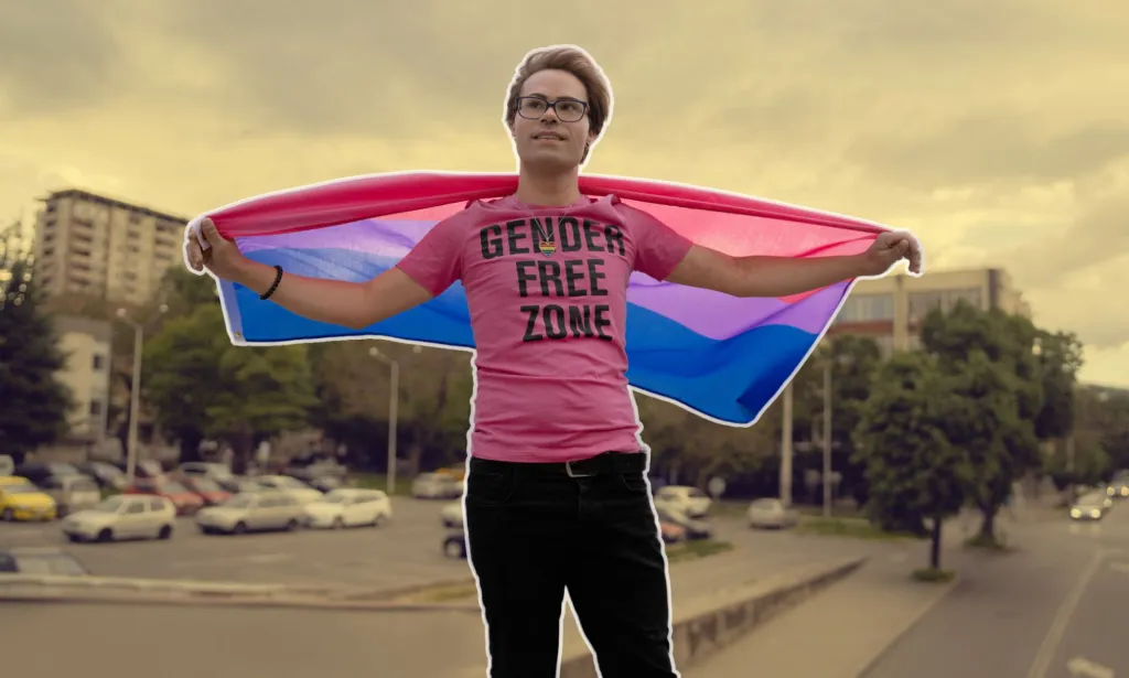 Il s'agit d'une image décorative d'une personne non binaire posant avec le drapeau bisexuel.  Ils sont surmontés d'un fond stylisé.